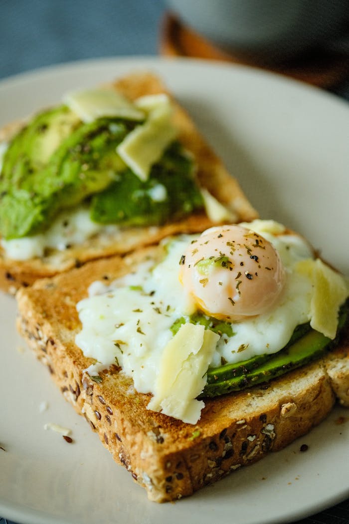 Savor the taste of creamy avocado toast topped with a perfectly poached egg and cheese.